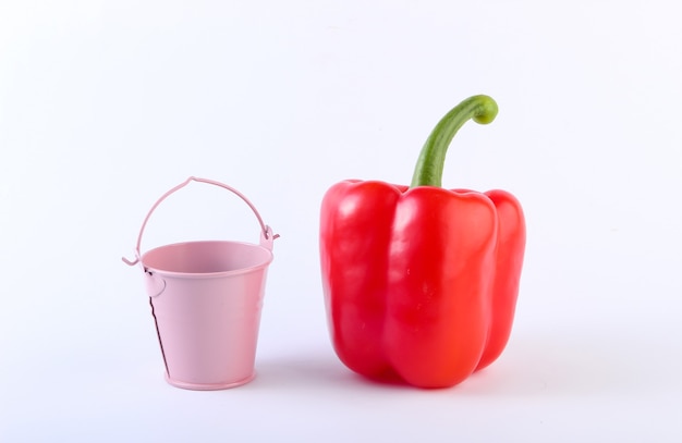 Paprika und ein Mini-Eimer auf einem weißen