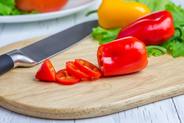 Paprika vermelha fatiada na placa de madeira