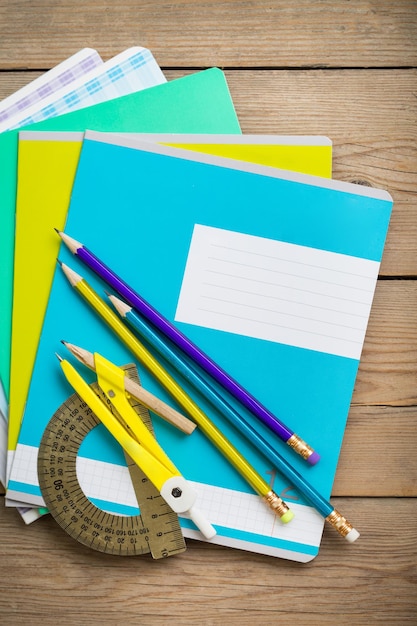 Foto un paquete de cuadernos para la escuela se encuentra en la vieja mesa de madera