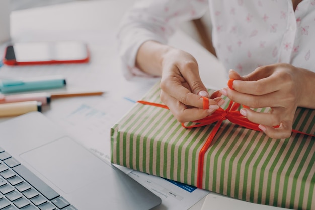 Paquete de embalaje de manos femeninas caja de regalo para el cliente durante las vacaciones de invierno de navidad