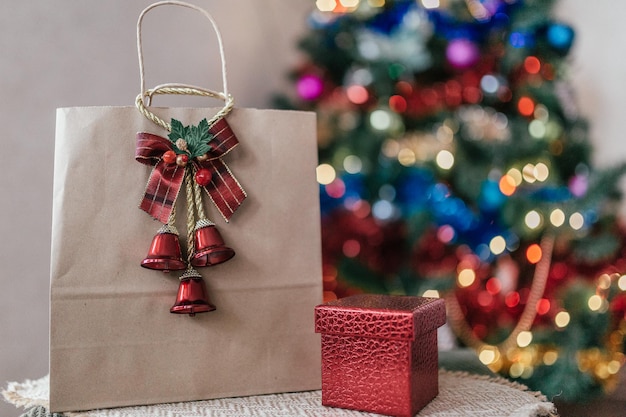 Paquete de manualidades con un regalo en el fondo de un árbol de Navidad