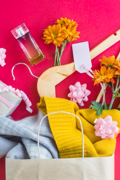 Foto paquete de papel artesanal con las compras de las mujeres - ropa, regalos, perfumes, flores