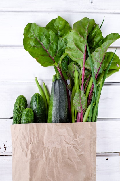 Paquete de papel lleno de vegetales verdes frescos