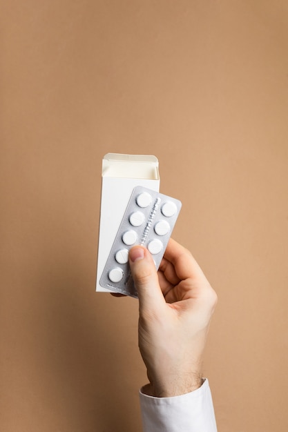 Paquete de pastillas en maqueta de manos masculinas