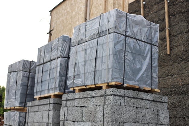 Foto paquete de piedra de pavimento en celofán en paletas de madera para la construcción de casas lugar de construcción