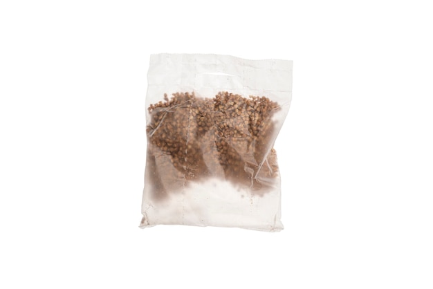 Un paquete de plástico con semillas de maíz de avena cruda para una cocción rápida aislado sobre fondo blanco.