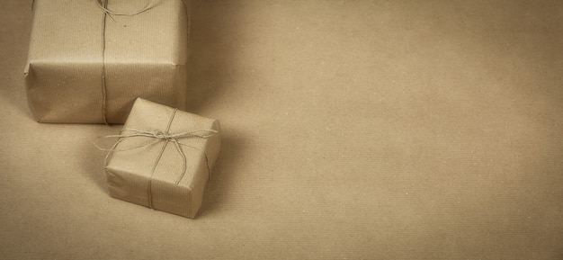 Paquete de regalo dos envuelto con papel marrón liso y cuerda y textura de fondo de papel marrón, caja de regalo retro. espacio de copia del concepto actual