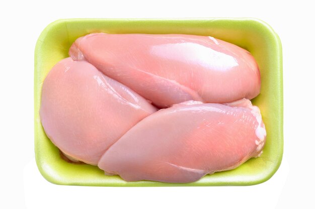 Paquete verde de filete de pollo crudo, aislado en un fondo blanco. Tres mitades de pechuga de pollo en un paquete, vista superior