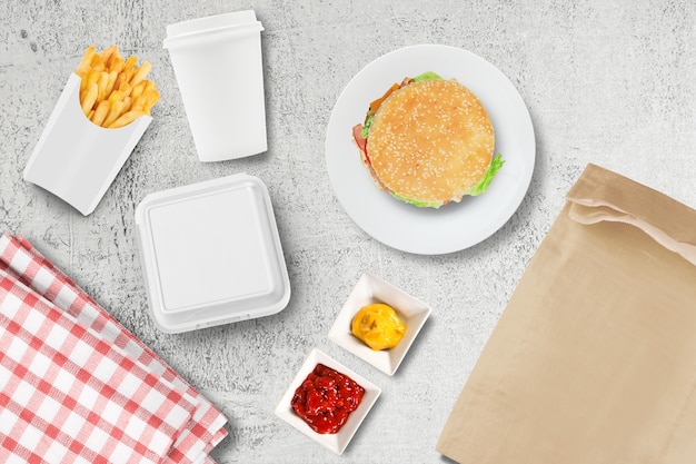 Paquete de vidrio y hamburguesas de papel en blanco en una mesa de restaurante