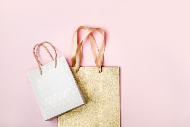 Paquetes de blanco y oro sobre fondo rosa. Concepto de venta de vacaciones en colores pastel.