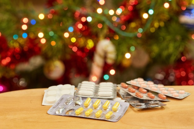 Foto paquetes de pastillas contra el fondo de luces navideñas borrosas de guirnaldas navideñas