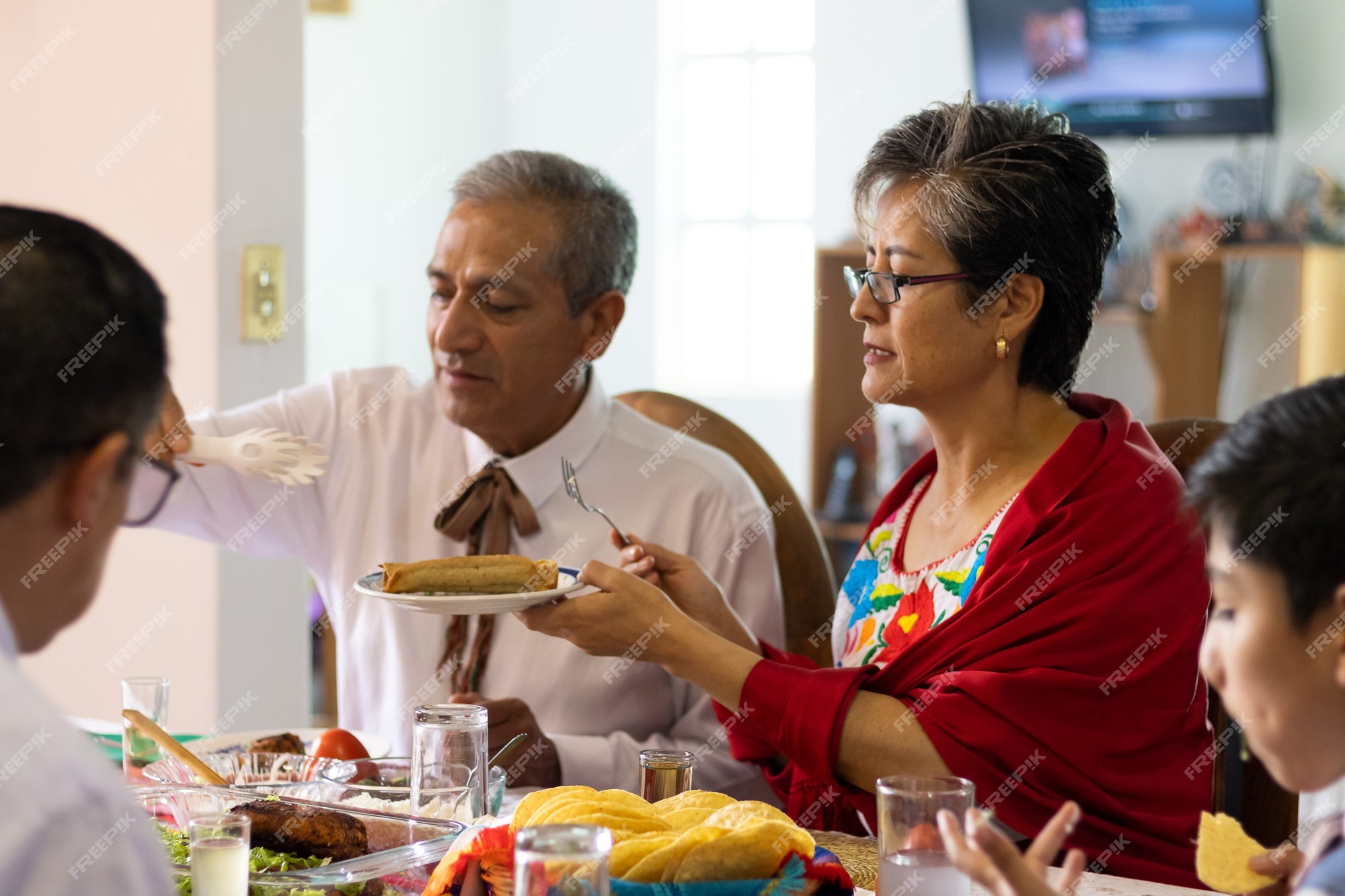 Un par de adultos vestidos con trajes típicos mexicanos sentados en una mesa en una cena mexicana comiendo comida típica mexicana | Foto Premium Un par de adultos vestidos con trajes típicos mexicanos sentados en una mesa en una cena mexicana comiendo comida típica mexicana | Foto Premium