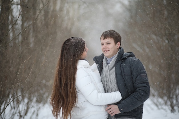 Un par de amantes en una fecha tarde de invierno en una ventisca de nieve