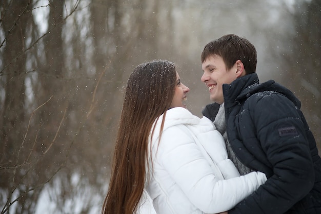 Un par de amantes en una fecha tarde de invierno en una ventisca de nieve
