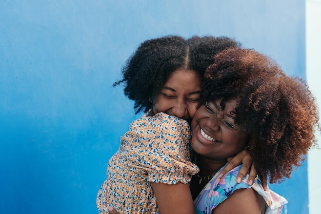 Un par de amigos negros abrazándose cariñosamente