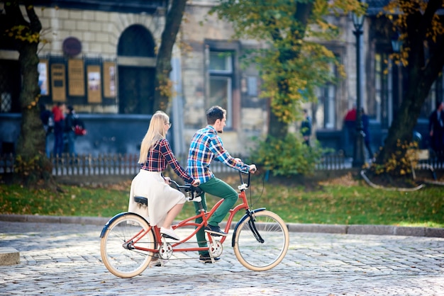 par, andar bicicleta tandem, ao longo, rua pavimentada, cidade