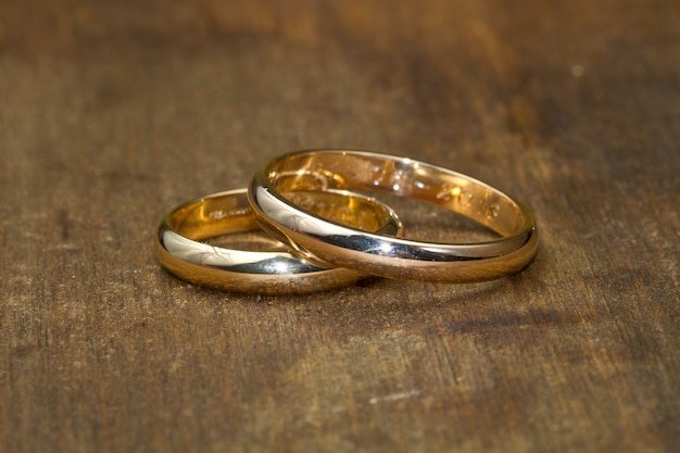 Par de anillos de boda en mesa de madera