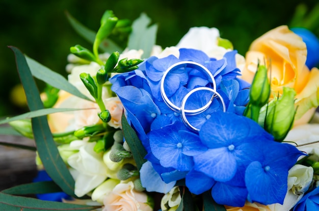 Par de anillos de boda en ramo de novia