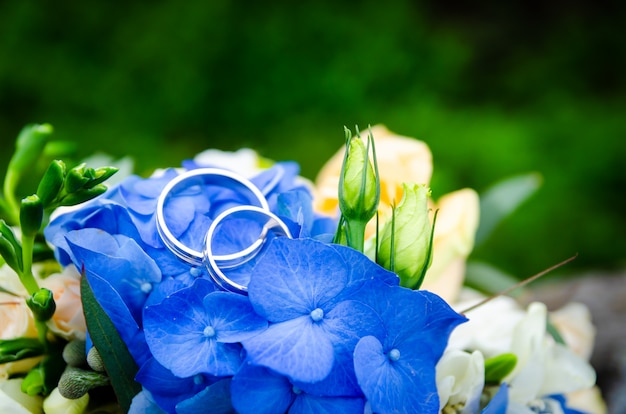 Par de anillos de boda en ramo de novia