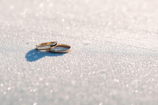 Un par de anillos de bodas de oro en la nieve.Dos anillos de bodas