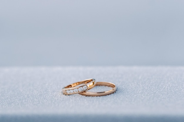 Un par de anillos de bodas de oro en la nieve.Dos anillos de bodas