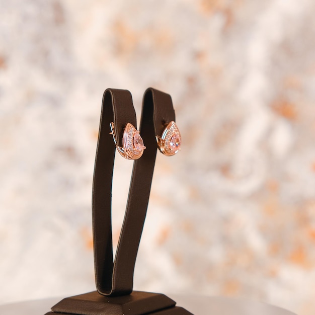 Un par de aretes con un diamante rosa en la parte superior.