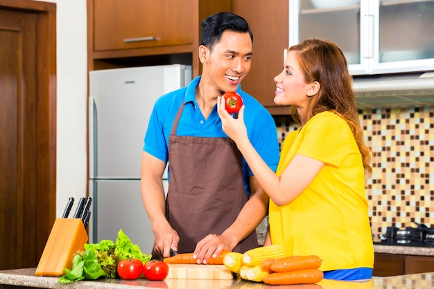 Par asiático, preparando alimento, em, cozinha doméstica