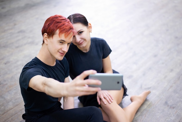 Par de bailarines tomando selfie en el teléfono móvil después del entrenamiento