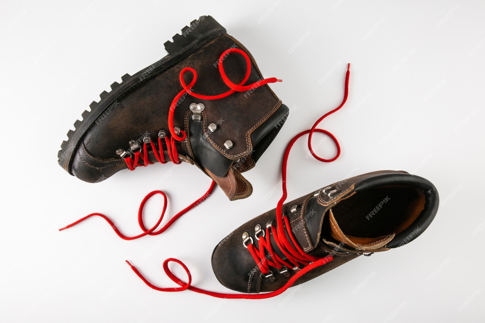 Par botas de montaña vintage con cordones rojos fondo blanco. | Premium