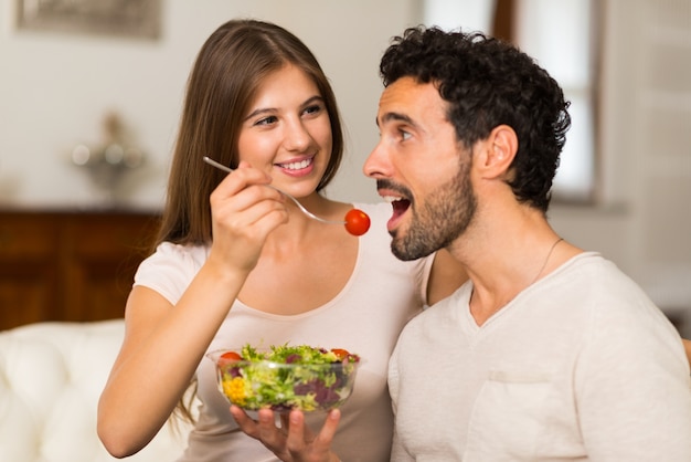 Par comer una ensalada en la sala de estar. Profundidad de campo, se centran en la mujer