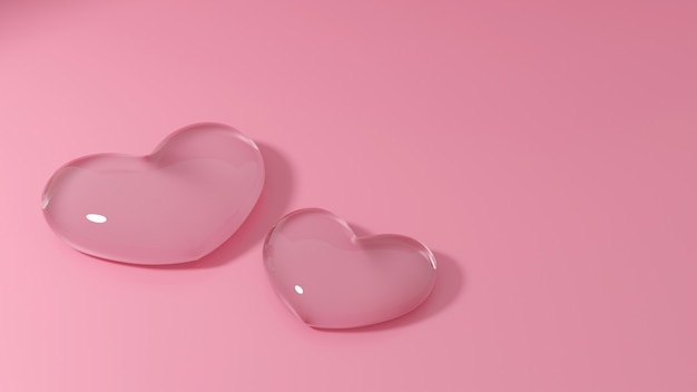 Par de corazones de vidrio transparente sobre fondo rosa