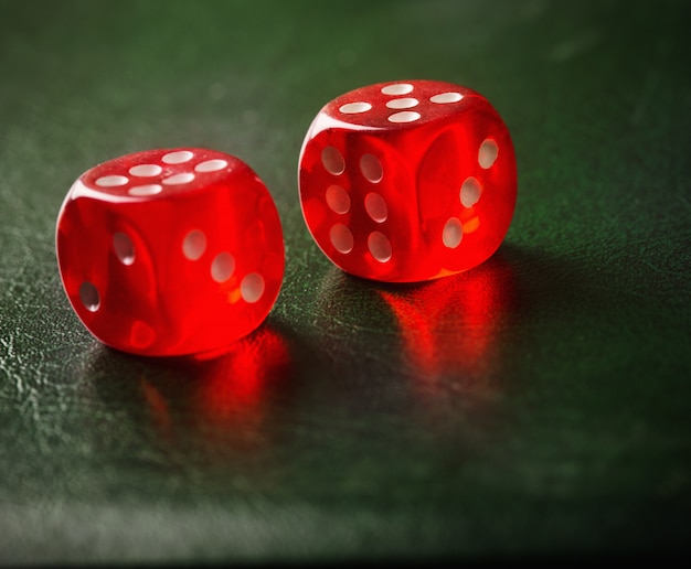 Foto par de dados rojos arrojados sobre mesa verde