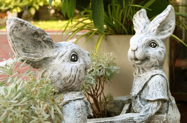 Par de adoráveis esculturas de coelhinhos da Páscoa no quintal