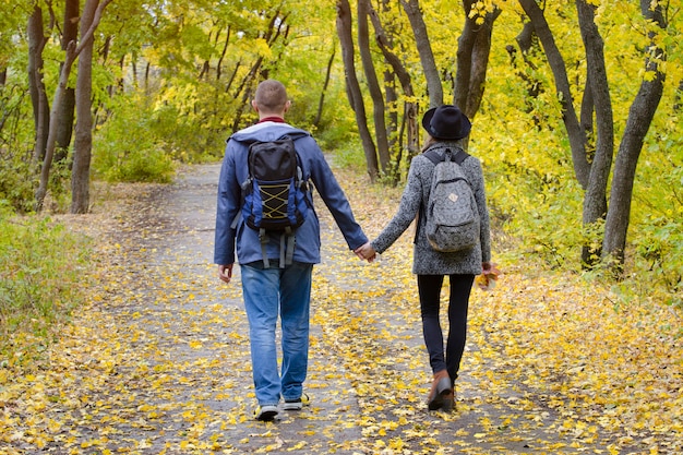 Par de amantes andando no parque outono