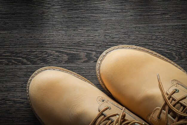 Par de botas de trabalho impermeáveis na placa de madeira vintage