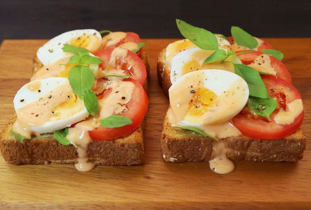 Par de deliciosos sanduíches de ovos cozidos com tomate e manjericão