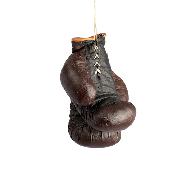 Par de luvas de boxe de couro marrom vintage muito velho pendurado em uma corda