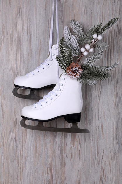 Par de patins de gelo com decoração de Natal pendurado na parede de madeira