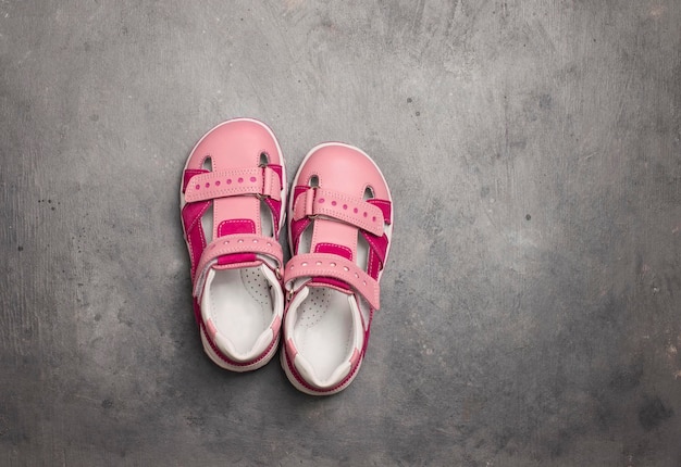 Par de sandálias de couro em fundo cinza com espaço de cópia Sandálias de verão rosa bebê