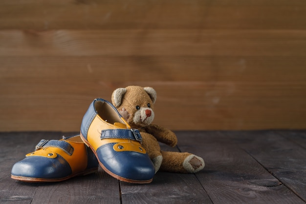 Foto par de sapatos de bebê na mesa de madeira