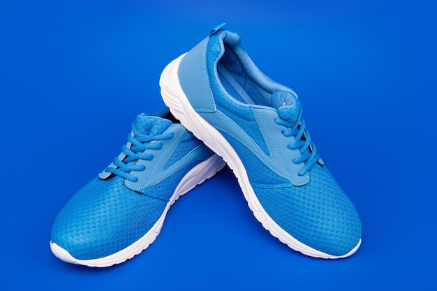 Par de sapatos esportivos confortáveis sapatos de tênis azuis esportivos em fundo azul loja de sapatos conceito de compras calçados para treinamento de calçados esportivos para corrida