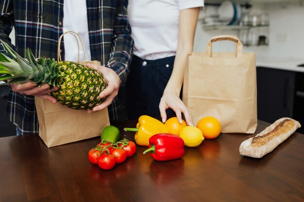 Par desembalar productos frescos del mercado sobre la mesa