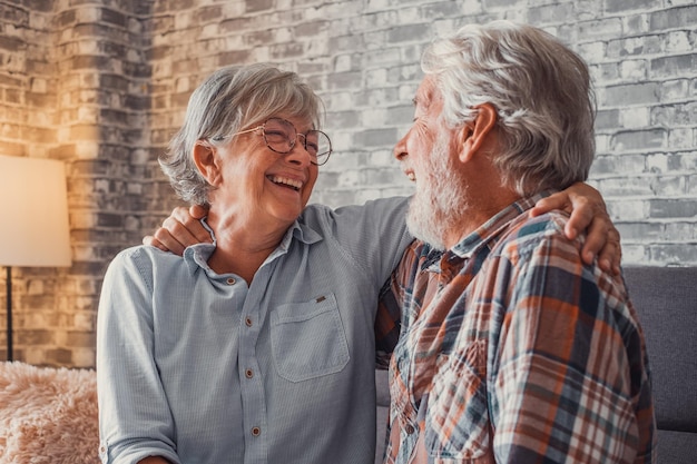 Un par de dos ancianos divirtiéndose juntos y disfrutando en el sofá de casa Personas maduras hablando y riendo abrazadas