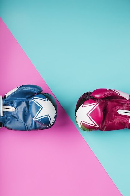 Un par de guantes de boxeo azules y rosas sobre un fondo azul y rosa