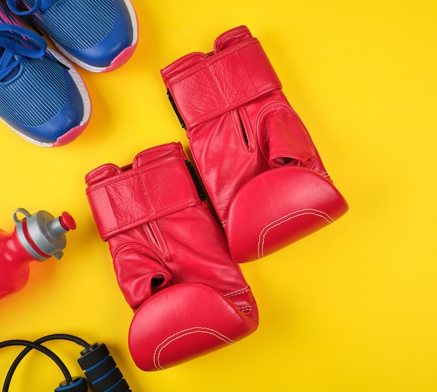 Par de guantes de boxeo rojos y zapatillas azules, vista superior