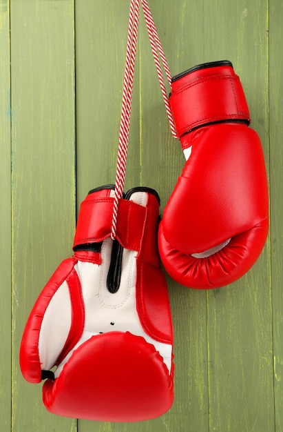 Par de guantes de boxeo sobre fondo de madera de color