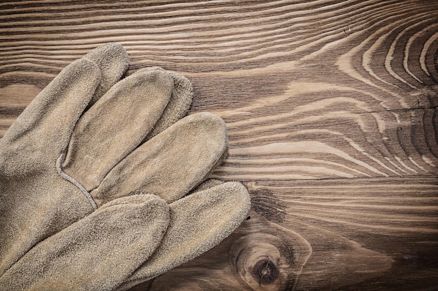 Par de guantes protectores en concepto de construcción de tablero de madera vintage