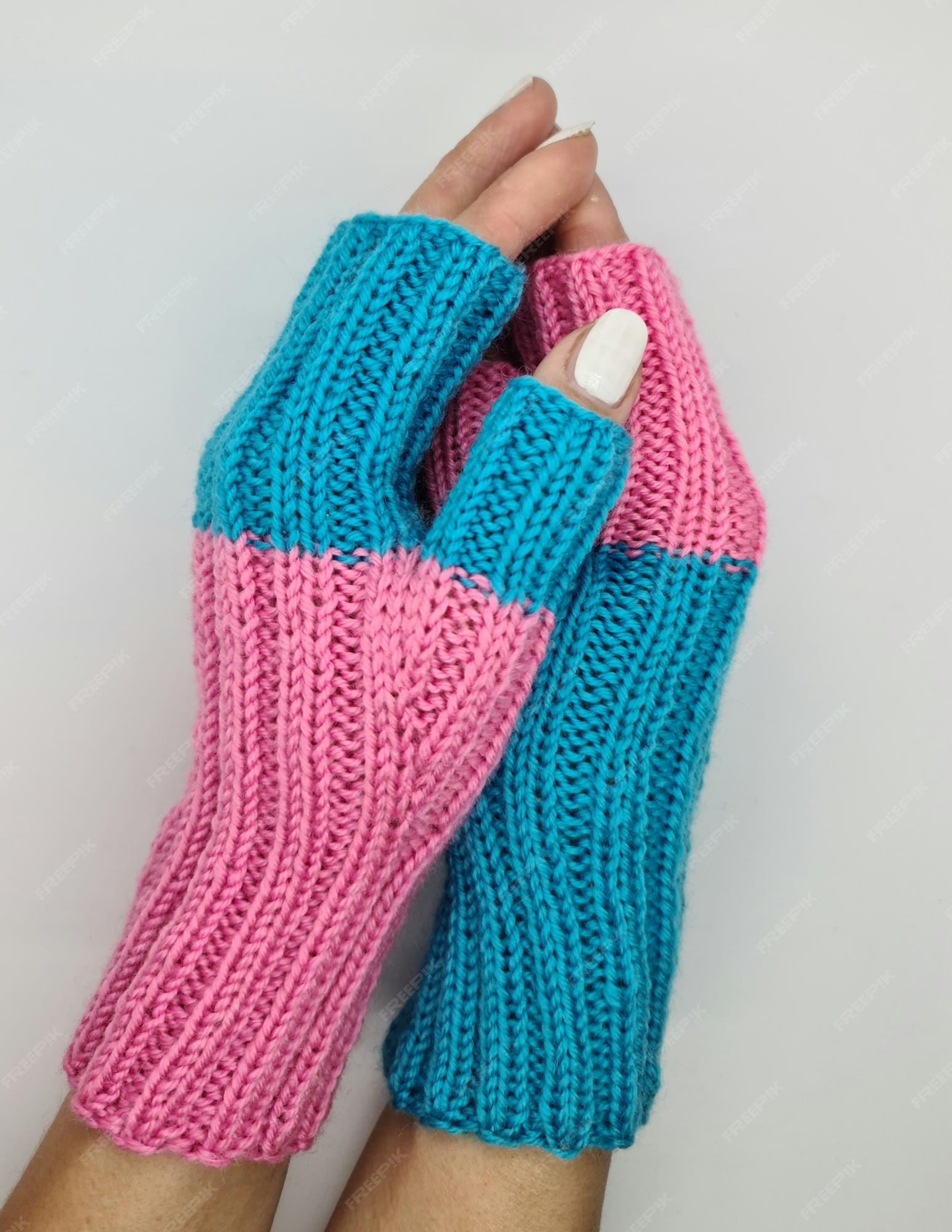 Un par de tejidos con guantes dedos rosas y azules. |