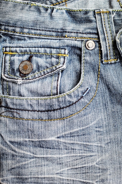 Un par de jeans azules con un botón en el bolsillo delantero.