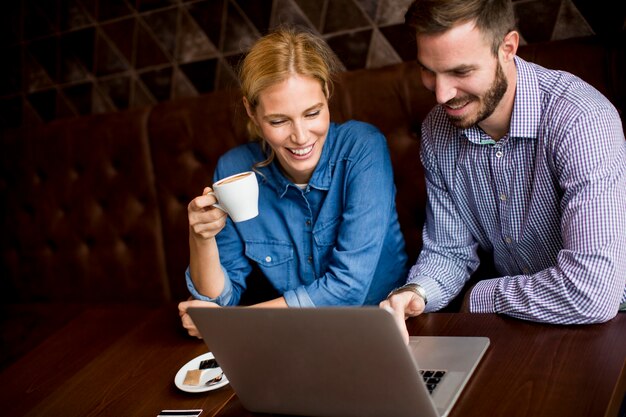 Par jovem, com, laptop, em, restaurante